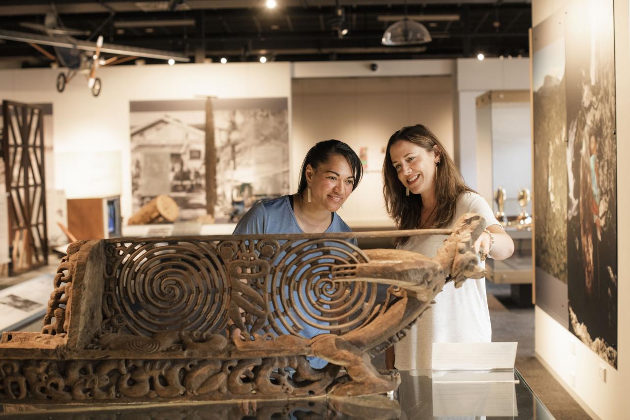 People admiring traditional carving in museum