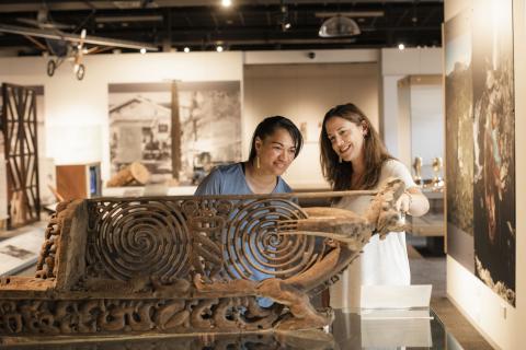 People admiring traditional carving in museum