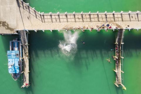 Aerial view of kids jumping off the wharf